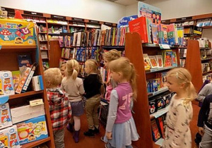 Dzieci stoją między regałami z książkami